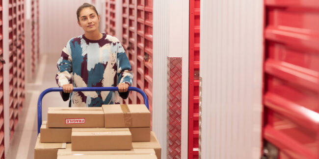 warehouse-container-storage A woman entrepreneur unloading boxes from a shipping container storage.